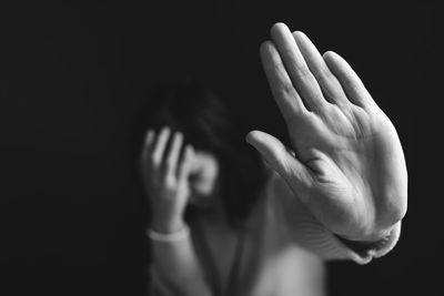 Close-up of woman against black background