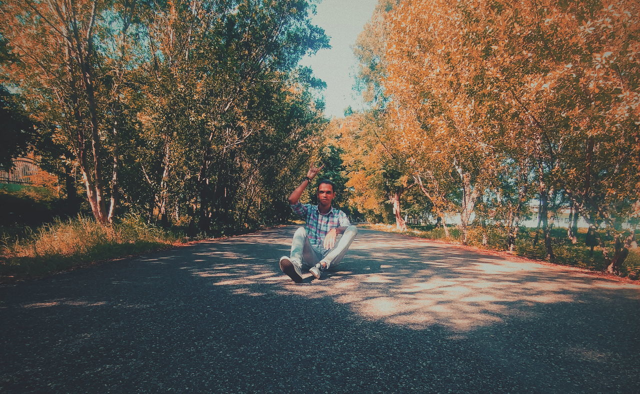 full length, tree, plant, one person, leisure activity, road, casual clothing, nature, transportation, real people, lifestyles, autumn, direction, change, day, young adult, the way forward, outdoors