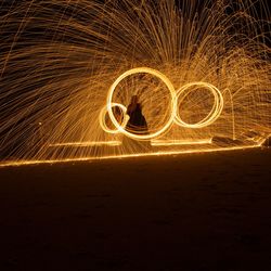 Silhouette person making light painting at night