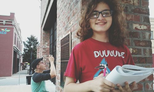 Portrait of young woman standing on wall