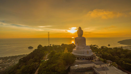 Statue at temple against sky during sunset