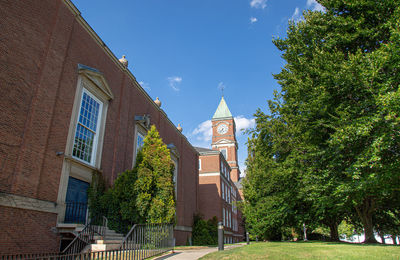 Low angle view of trees and buildings against sky