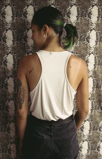 Rear view of woman standing against wall