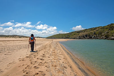 Man standing on beach against sky