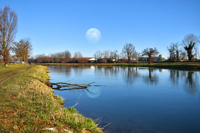 Scenic view of lake against clear blue sky