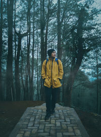 Full length of young man standing in forest