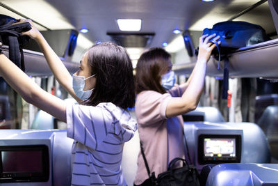 Rear view of women standing in bus