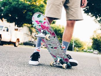 Low section of man skateboarding on road