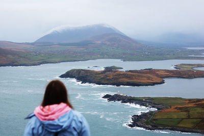 Rear view of woman looking at lake against scenic view on the beginish island