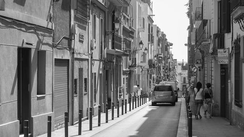 Vehicles on street amidst buildings in city