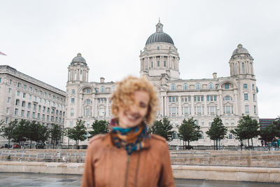 Full length of senior woman against buildings in city