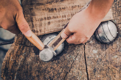 Cropped hands of man working on wood