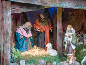 Nativity scene with figures - baby jesus, mary, joseph and a shepherd with sheep.