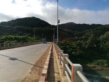 Road by trees against sky