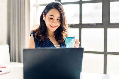 Portrait of a young woman drinking coffee cup