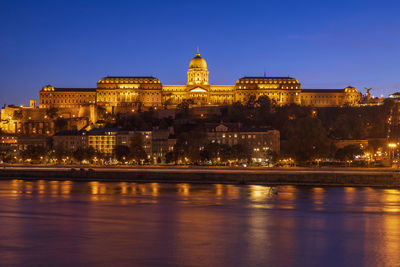 Illuminated buildings against sky in city