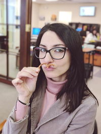 Portrait of woman holding pretzel at restaurant