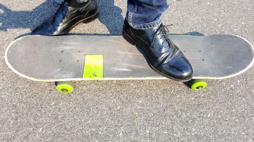 Low section of man skateboarding on road