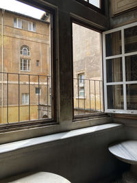 View through a window from the vatican museum with a piece of wooden sculpture on the wall