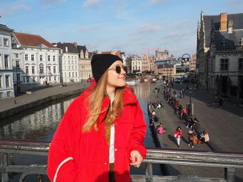 Woman standing by railing in city