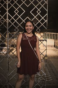 Portrait of smiling young woman standing outdoors before sunset