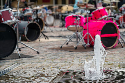 Close-up of a fountain on the background of a defocused paved area with many drum kits
