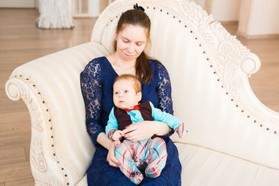 Full length of happy woman sitting at toy