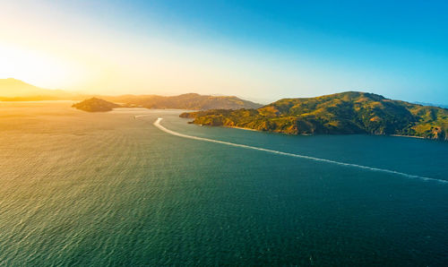 Aerial view of sea against mountains and sky