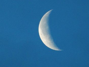 Low angle view of moon in blue sky