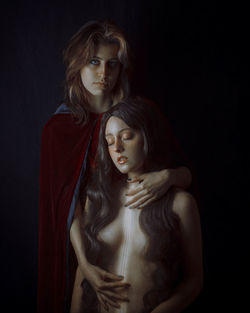 Portrait of a beautiful young woman over black background