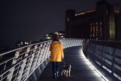 Rear view of man walking on street at night