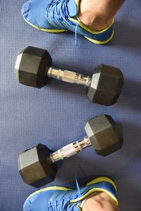 Low section of man by dumbbells at gym