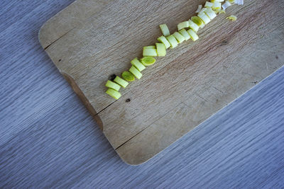 High angle view of chopped leek on cutting board at table