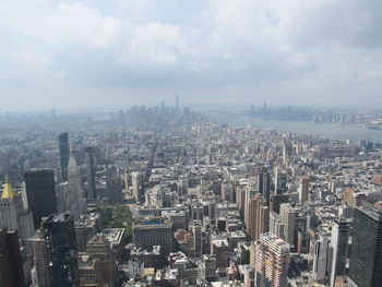 Aerial view of buildings in city against sky