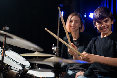 Midsection of man playing drum