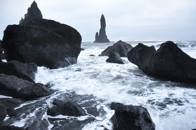 Rocks in sea against sky