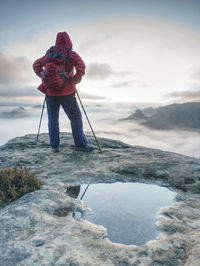 Young woman looking to misty nowhere. girl hiker alone lost in foggy cloud in high mountains.