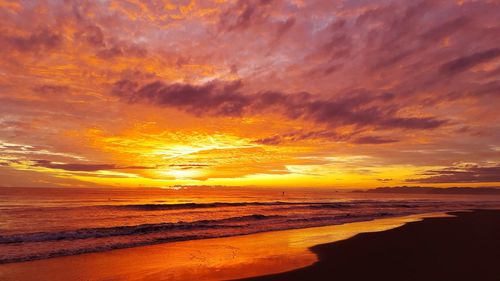 Scenic view of sea against dramatic sky during sunset