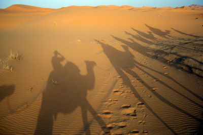 Shadow of people on sand dune in desert