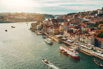 Oporto downtown ribeira do porto from the d. luis bridge in vila nova de gaia. sunset with sunglare.