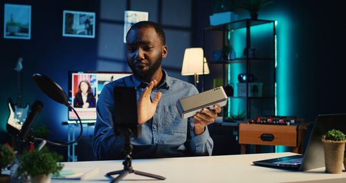 Portrait of young man using mobile phone while sitting in office