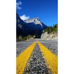 Road passing through mountains against cloudy sky