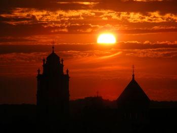 Silhouette built structures against sky during sunset