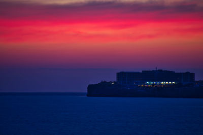 Scenic view of sea against romantic sky at sunset