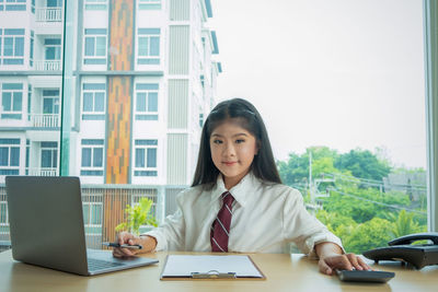 Portrait of businesswoman sitting at desk in office