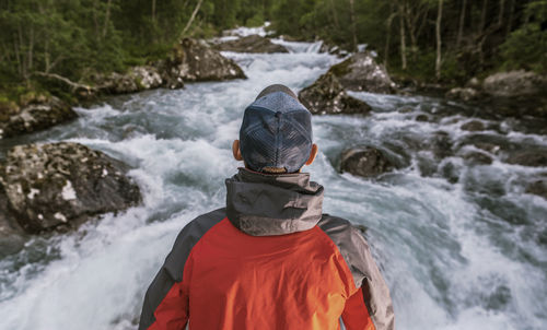 Rear view of man standing in river