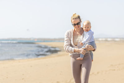 Portrait of young woman standing at beach