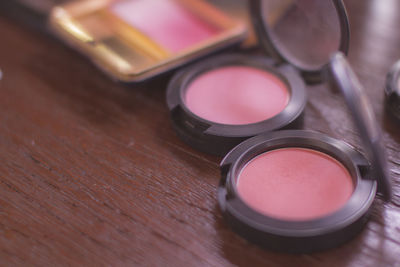 Close-up of powder compact on wooden table