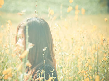 Portrait of woman with flowers on field