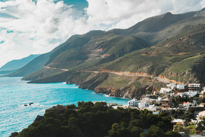 Scenic view of sea and mountains against sky